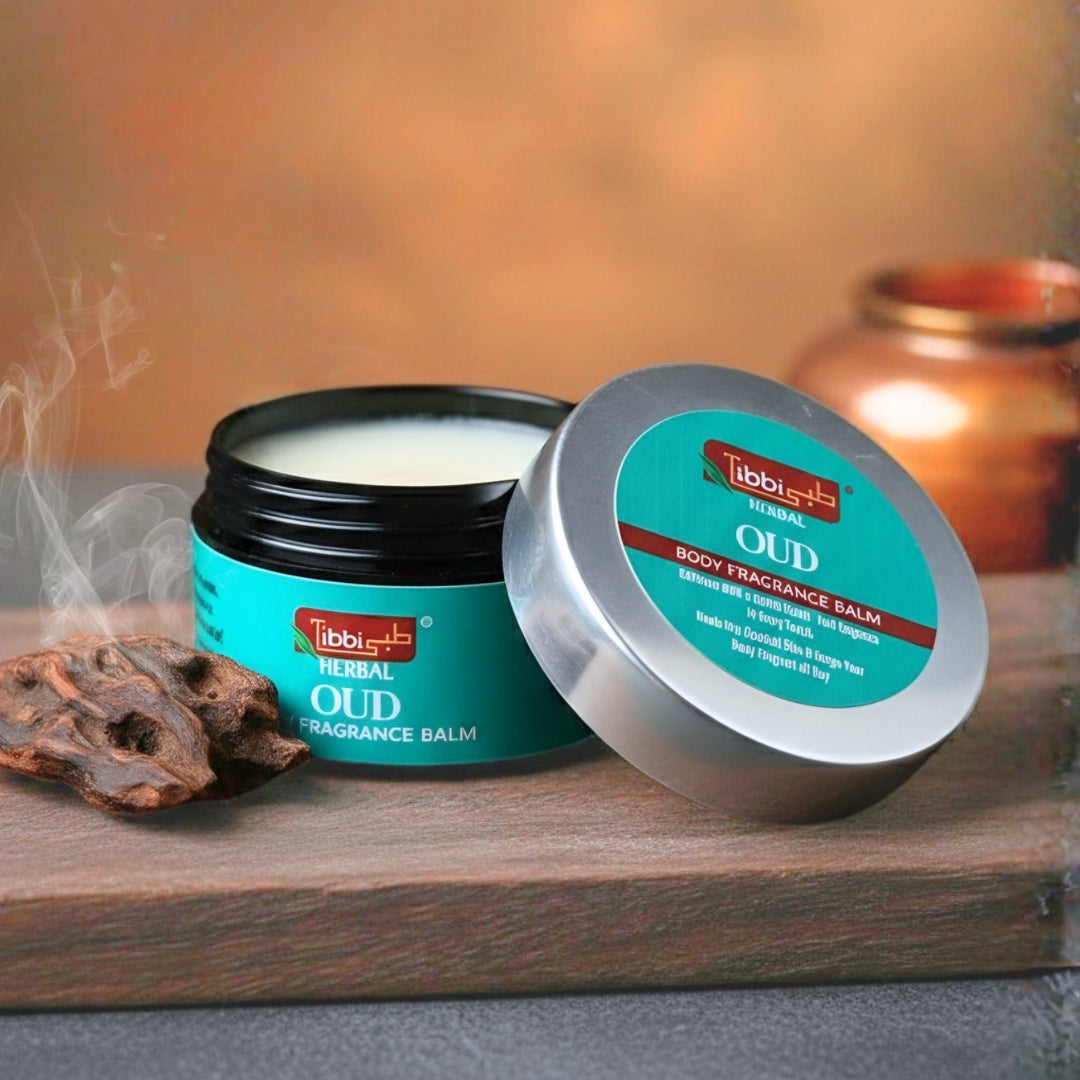 Herbal Oud fragrance balm with open lid on a wooden surface, surrounded by oud resins and a candle.